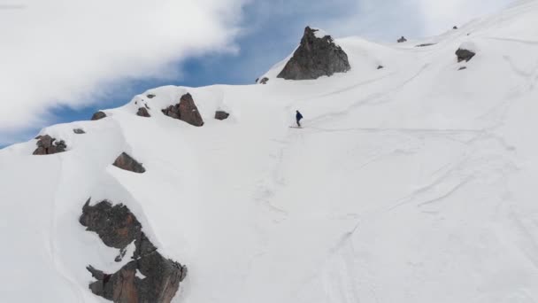 Widok z lotu ptaka męskiego sportowca, narciarza wspinającego się na strome zbocze. Skitour freeride backcountry wspinaczka na nartach przez śnieg wysoko w górach Północnego Kaukazu — Wideo stockowe