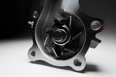 Otomobil motorunun sıvı soğutma pompasının yakın çekimi. Gri gradyan arkaplanda yeni bölüm