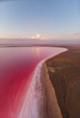 Pembe tuz gölünün günbatımında gökyüzü manzarası ve ufukta bulutlar.