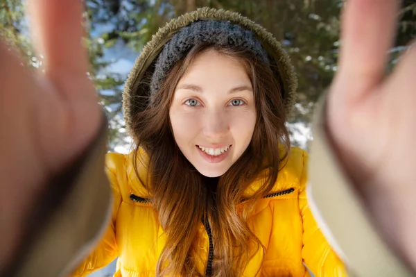 Amplo ângulo atraente jovem mulher tomando selfie na floresta de coníferas de inverno — Fotografia de Stock