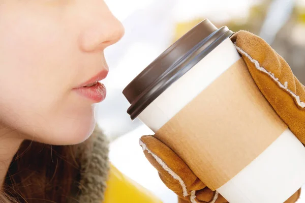 Close-up do fundo do rosto de uma jovem mulher caucasiana. Lábios e queixo ao lado de xícara de papel de café na floresta de inverno — Fotografia de Stock