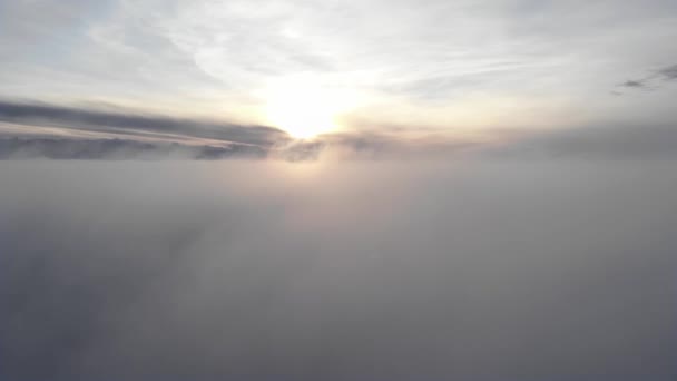 Неймовірний вид з повітря, знятий над звивистим туманом і хмарами на заході сонця в горах. Політ над низькою хмарною поверхнею з хребтом на задньому плані — стокове відео