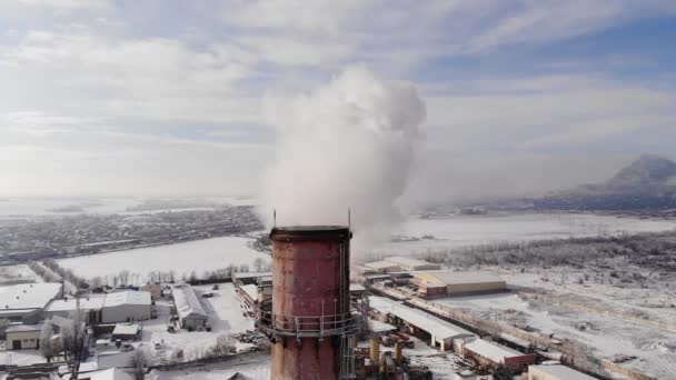 Close-up zicht op CHP schoorstenen met rook in het avondlicht. Luchtfoto van het industriegebied in de winter in een stad omringd door bergen — Stockvideo