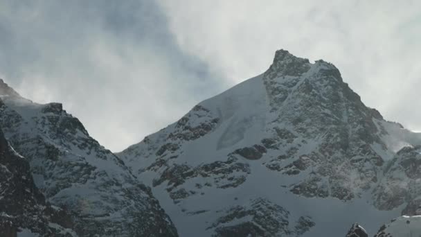随着风从山顶吹来的雪，在高山白雪覆盖的山峰上的心灵感应镜头上，时间流逝了。山区恶劣的气候条件 — 图库视频影像