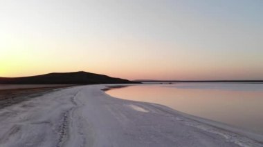 Havadan aşağıya doğru eğilmiş Pembe Tuz Gölü alçak anahtarı. Sinematik film tahılları. Akşam çekimi.