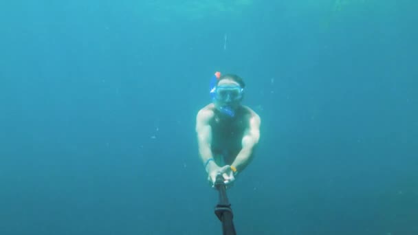 Moře. Muž v podvodní masce a ploutve s šnorchlem plave v moři se selfie holí. Egypt. Podvodní svět na akční kameře — Stock video