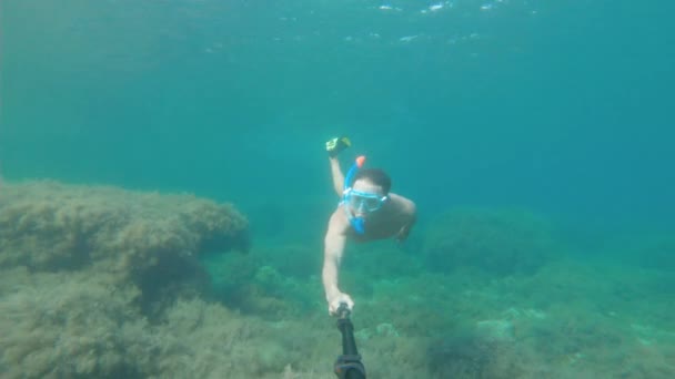 Meer. Ein Mann mit Unterwassermaske und Flossen schwimmt mit einem Selfie-Stick im Meer. Ägypten. Unterwasserwelt auf einer Action-Kamera — Stockvideo