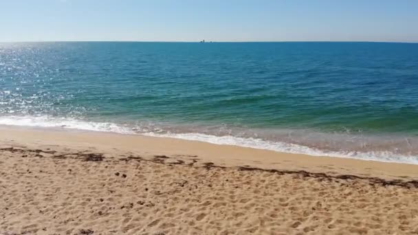 海の青い波の空中トップビューは、ビーチでクラッシュします。無人機から撮影された海の波と美しい砂浜の空撮. — ストック動画