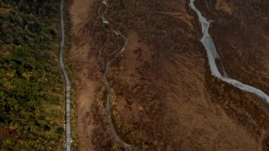 Dağ vadisinden akan bir nehir. Yukarıda, dar, dolambaçlı bir nehrin, asfalt bir yolun yanında pitoresk bir hava manzarası var. Dünyanın en güzel yolları.