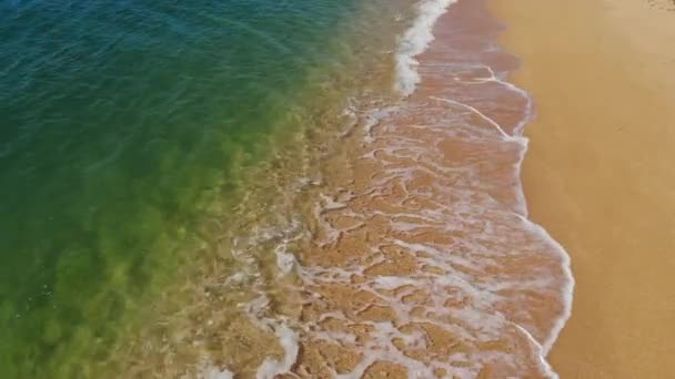 Widok z góry oceanu niebieskie fale rozbijają się na plaży. Fale morskie i piękna piaszczysta plaża widok z lotu ptaka. — Wideo stockowe