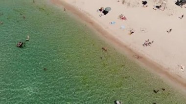 Orta Asya 'nın gökyüzü manzarası, dinlenen turistler ve plaj şemsiyeleri. Deniz kenarında turizm ve eğlence için arka plan
