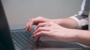 Yakın plan beyaz kadın parmaklarıyla evde mutfak masasında dizüstü bilgisayarla yazı yazıyor..