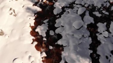 Karla kaplı kıyı dağı nehir akıntısı üzerindeki hava manzarası. Doğanın kış manzarası, hiç kimse. Buz gibi karlı dağ ormanlarının doğal güzelliği. Çam ağaçları dağları Alpler, İtalya, Avrupa