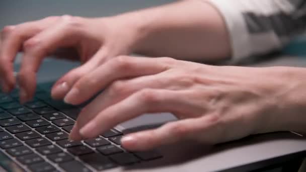 Yakın plan beyaz kadın parmaklarıyla evde mutfak masasında dizüstü bilgisayarla yazı yazıyor.. — Stok video