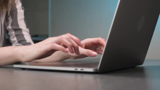 在家里厨房桌子旁的笔记本电脑键盘上用手指打字的高加索年轻女性特写. — 图库视频影像