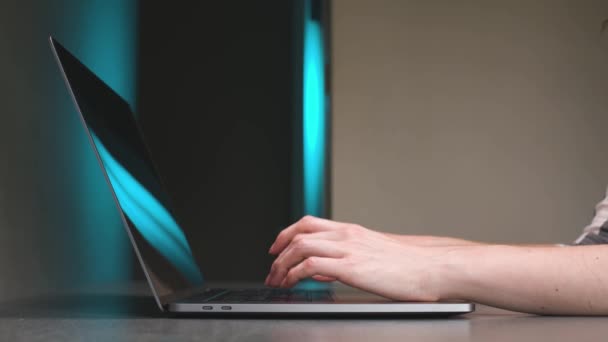 Lähikuva Valkoihoinen nuori nainen kirjoittaa sormilla kannettavan tietokoneen näppäimistöllä keittiön pöydässä kotona. — kuvapankkivideo