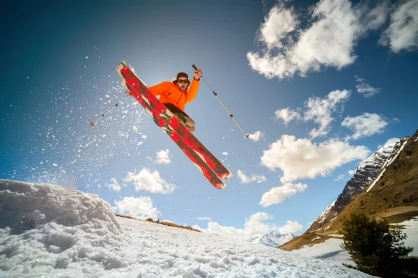 Flyga unga kaukasiska mannen hoppar från en språngbräda på skidor — Stockfoto