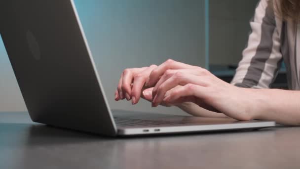 Close-up Kaukasische junge Frau tippt mit den Fingern auf Laptop-Tastatur am heimischen Küchentisch. — Stockvideo