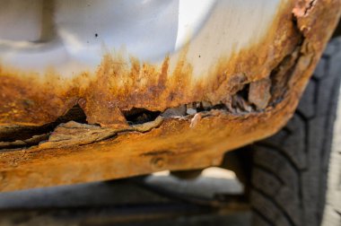 Pas tutmuş bir araba parçası. Paslı bir arabanın kanat parçası. Vücut elementleri aşınmış. Konsept: Aşınma direnci, vücut onarımı, pas. Koruma.