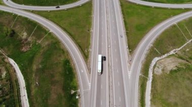 Hareket halindeki birkaç araçla banliyö kavşağının havadan görüntüsü. Kenar mahalle yol altyapısı konsepti. Sıcak bir yaz günü. Yumuşak ışık.