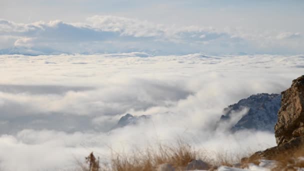 Hoch in den Bergen ziehen im Zeitraffer tagsüber Wolken von epischen Felsen herab. Wolkenfluss — Stockvideo