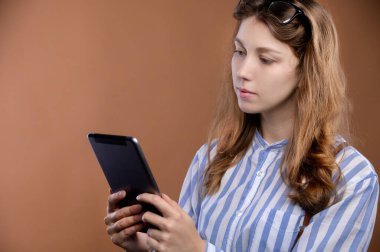 Çekici beyaz kız öğrencinin stüdyo portresi çizgili gömlek ve pantolon askılı etek giyiyor..