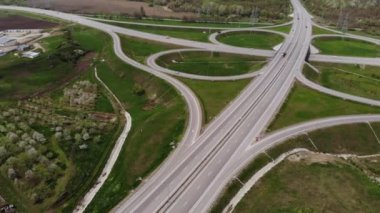 Hareket halindeki birkaç araçla banliyö kavşağının havadan görüntüsü. Kenar mahalle yol altyapısı konsepti. Sıcak bir yaz günü. Yumuşak ışık.