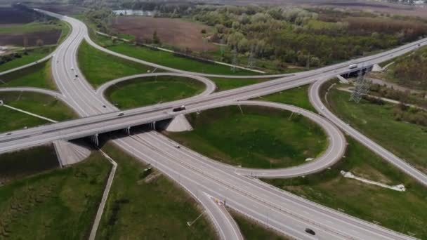 Widok z lotu ptaka na przedmieścia z kilkoma poruszającymi się pojazdami. Koncepcja podmiejskiej infrastruktury drogowej. Ciepły letni dzień. Miękkie światło. — Wideo stockowe