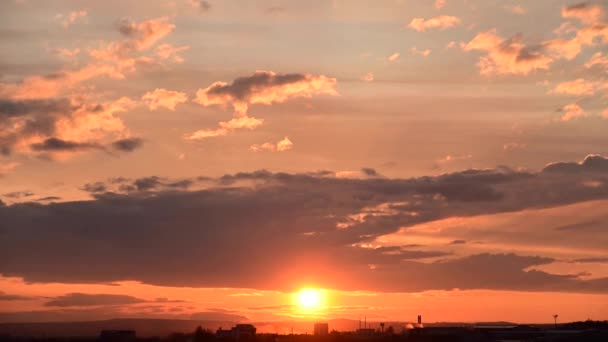 Naplemente egy kisváros peremén, mozgó felhőkkel az égen, narancssárga árnyalatokkal. Zoom-hatás — Stock videók