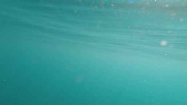 Dalgaların yüzeyinin yansımasında suyun altından deniz arka planının soyut görüntüsü ve güneş ışınları parlıyor ve parlıyor. — Stok video
