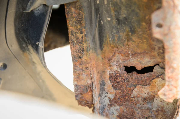 Close-up Lichaamsreparatie- en laswerkzaamheden vereist. Rust op een grijze oude auto. Roest gat op een oud versleten geschilderd metalen oppervlak. — Stockfoto