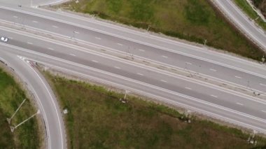 Yukarıdan bak. Hareket halindeki birkaç araçla banliyö kavşağının havadan görüntüsü. Kenar mahalle yol altyapısı konsepti. Sıcak bir yaz günü. Yumuşak ışık.