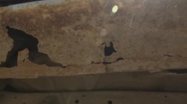 Gri, eski bir arabanın üzerinde derin bir pas var. Eski, yıpranmış metal yüzeydeki pas ve aşınma deliği. Vücut parçaları tamiri. Tamir gerekiyor..