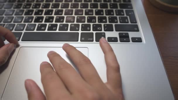 Close-up of young caucasian womans hand on laptop work with touchpad. Remote work on a laptop. Sideways movement — Stock Video