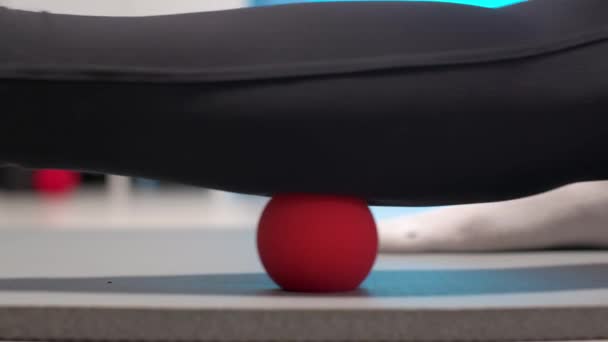 Close-up of self-massage of a sports woman indoors using a massage ball. Myofascial massage without a masseur. Elimination of pain in leg muscles — Stock Video