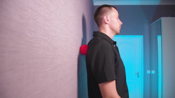 Mladý bělošský masér provádí masáž zad gumovou koulí. Inovativní myofáziální relaxační masáž při sebeizolaci — Stock video