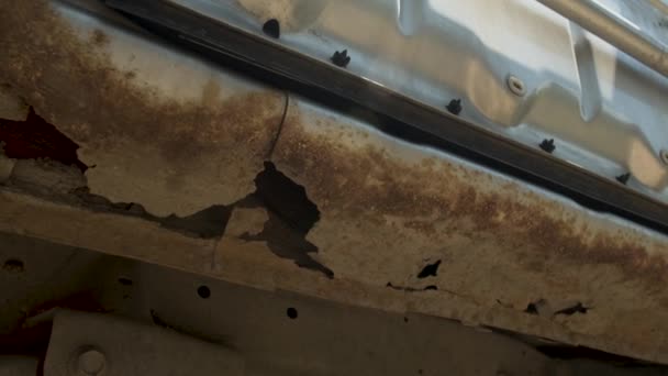 Gros plan de la corrosion par perforation destructrice sur une voiture argentée. Glissement latéral. Besoin de réparation du corps. Un exemple de corrosion corporelle sévère — Video