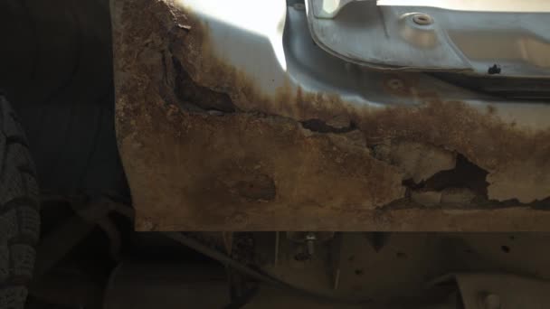 Close-up van destructieve doorslag corrosie op een zilverkleurige auto. Schuif opzij. Moet worden gerepareerd. Een voorbeeld van ernstige lichaamscorrosie — Stockvideo
