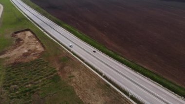 Hareket halindeki birkaç araçla banliyö otomobil pistinin havadan görüntüsü. Kenar mahalle yol altyapısı konsepti. Sıcak bir yaz günü. Yumuşak ışık.