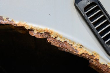 Arabanın üzerinde paslı tekerlek kemerleri var. Araba aşınması. Araç gövdesinin restorasyonunda kaynak çalışması için arka plan