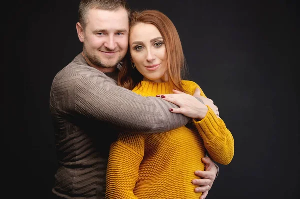 Πορτρέτο ενός ελκυστικού Καυκάσου παντρεμένου ζευγαριού που αγκαλιάζεται πάνω από μαύρο φόντο. Ευτυχισμένες οικογενειακές σχέσεις — Φωτογραφία Αρχείου