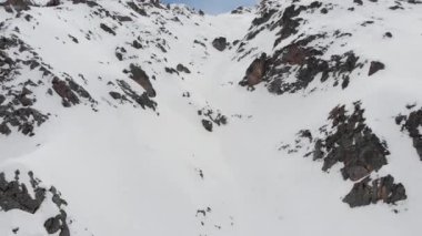 Dağlarda karla kaplı kayalık yamaçlar. Ekstrem kayak için dik bir yer. Gelişmiş biniciler için boş yer. Hava görünümü