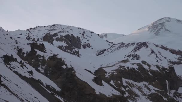 Handhållen panorama över snötäckta bergstoppar. Berg med livskameror vid solnedgången — Stockvideo