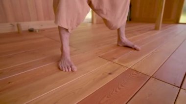 Sakallı, beyaz giysili beyaz bir adam. Qigong Tai Chi çalışmadan önce konsantrasyon ve nefes alma egzersizi yapıyor.