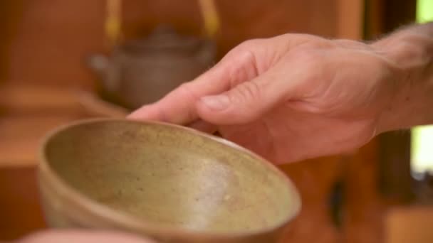 Un alfarero macho muestra su trabajo Yixing tetera de arcilla para una ceremonia de té hecho a mano cerca. Profundidad superficial del campo — Vídeos de Stock