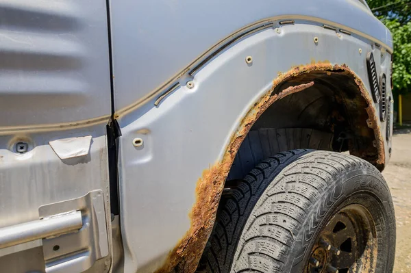 Rostiga hjulhus på bilen. bilkorrosion. Bakgrund för svetsarbete vid restaurering av karossen — Stockfoto