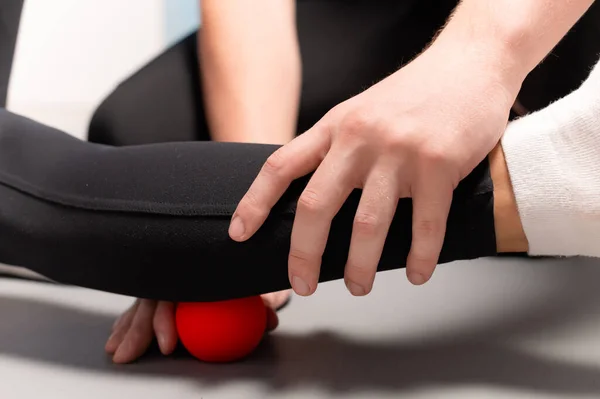 Fizioterapeutul predă auto-masajul cu bile roșii, pacient cu leziuni ale picioarelor. Tratamentul leziunilor sportive. Utilizare practică. Conceptul de reabilitare . — Fotografie, imagine de stoc