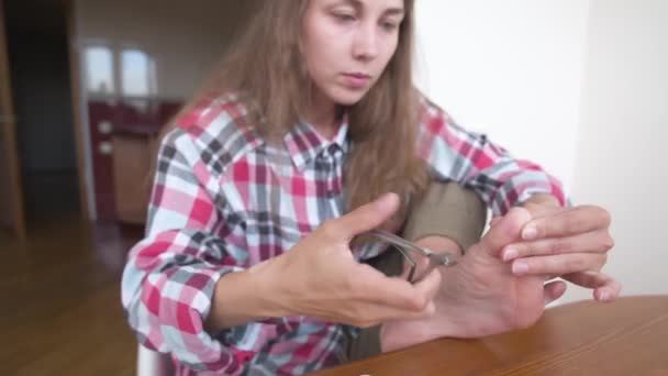 Ung kaukasisk kvinna gör sig själv en pedikyr hemma. Skötsel av naglar och tår. Vård av fotens hälsa — Stockvideo