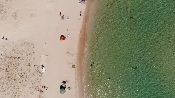 Arriba Vista aérea de una playa turística con gente descansando. Playa de arena del balneario en un día soleado. Recreación en la costa del océano — Vídeos de Stock