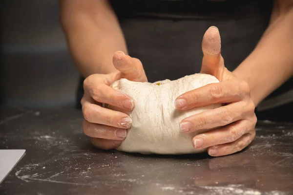 Primer plano de las manos femeninas amasando masa para hacer pan artesanal en la panadería casera — Foto de Stock